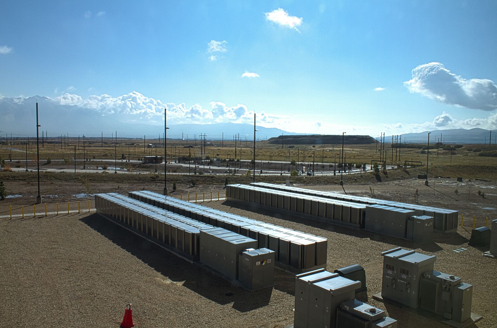 Data center construction site with equipment yard and mountains